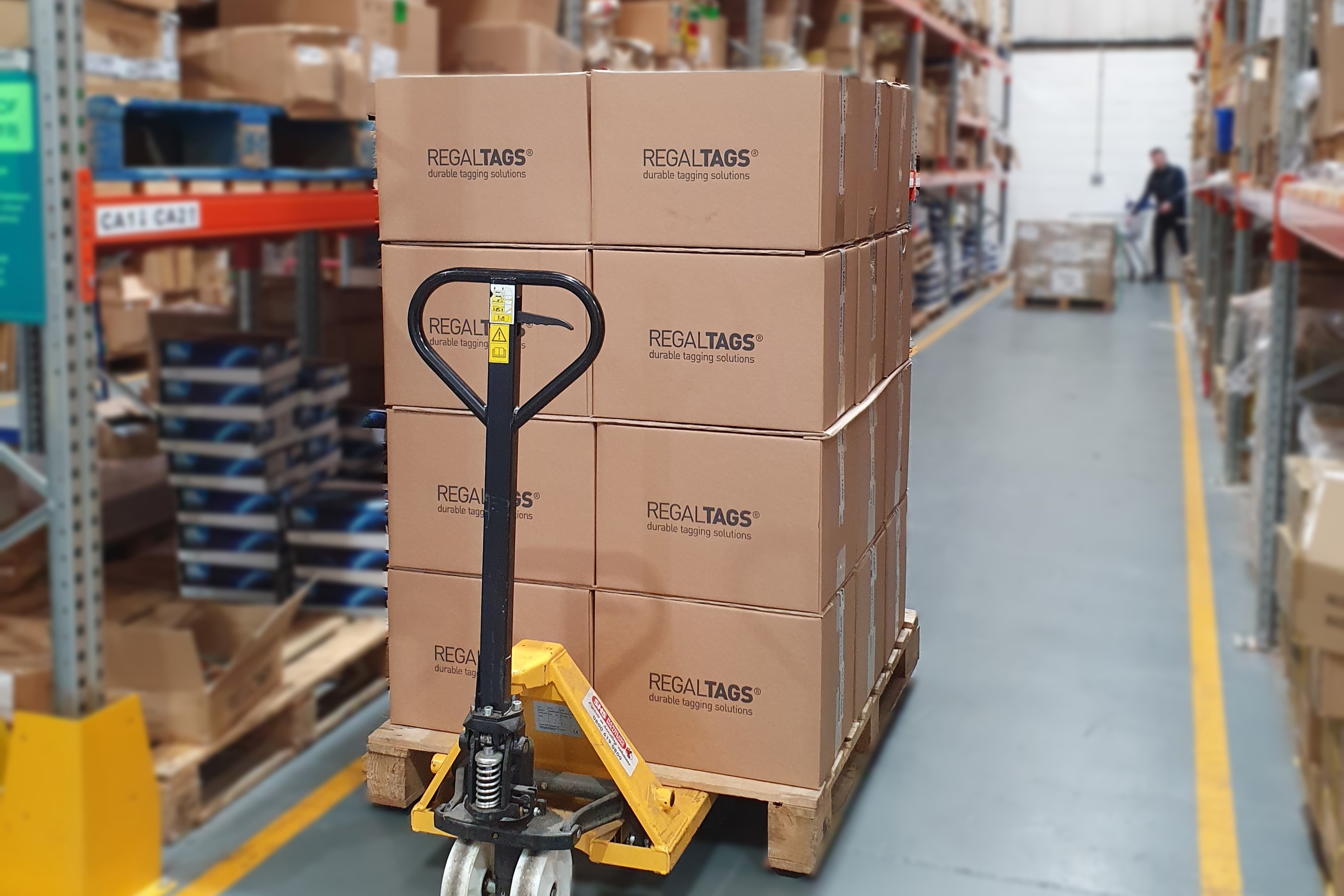 Man stacking boxes next to forklift