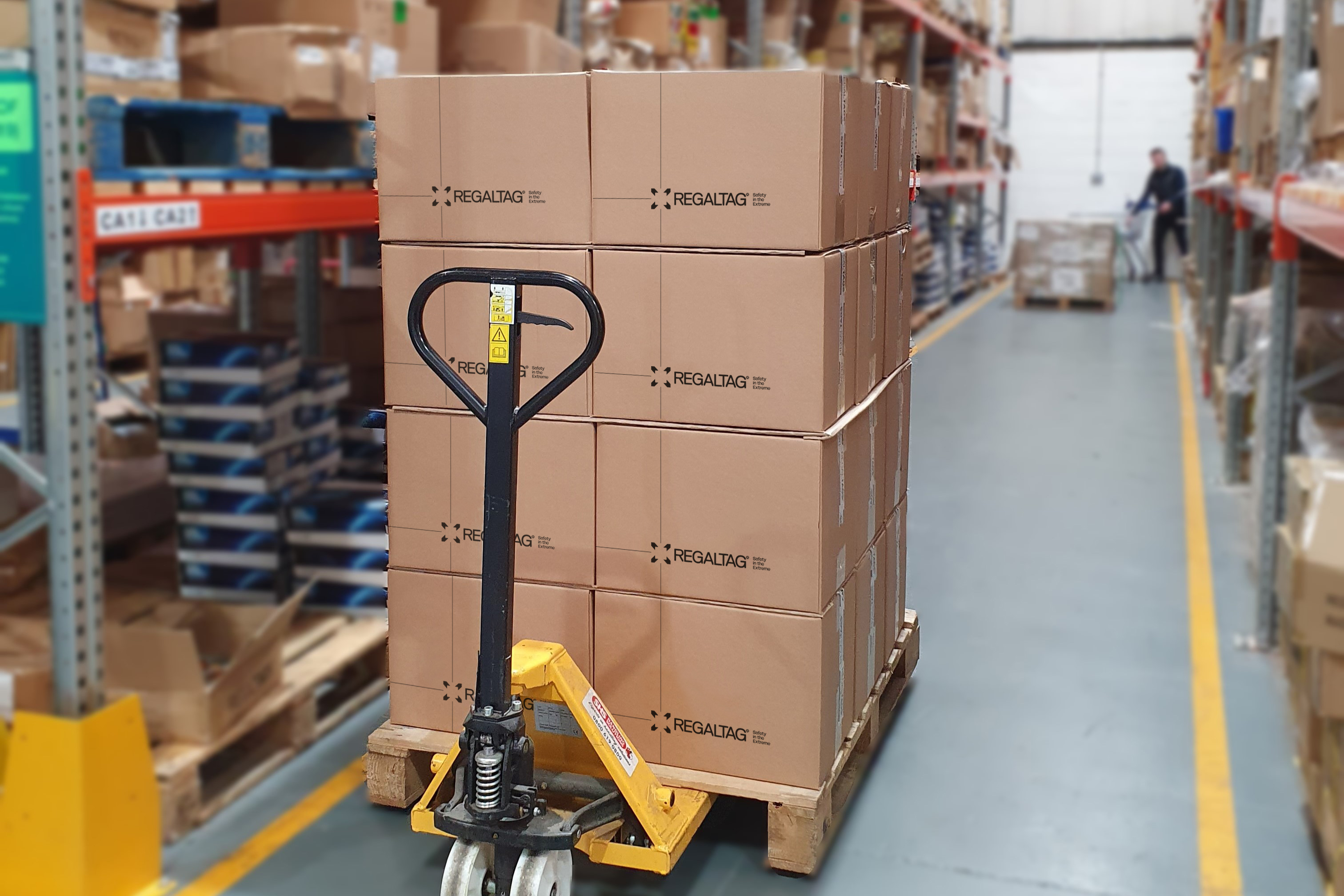 Man stacking boxes next to forklift